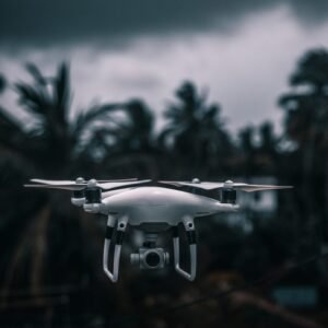 white drone flying in mid air during daytime
